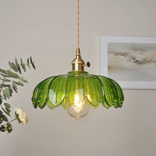 Een stijlvolle plafondlamp met een heldergroene glazen kap in de vorm van bloemblaadjes, die een warme gloed verspreidt. De lamp heeft een gouden fitting en een decoratieve gevlochten kabel, wat het moderne ontwerp accentueert. Perfect om elke ruimte een frisse en levendige uitstraling te geven